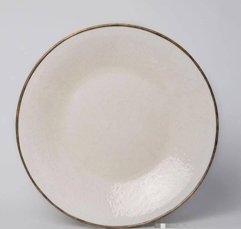 雍正時期仿定窯之作，與臺北故宮收藏的宋代定窯白釉雙魚盤十分相似